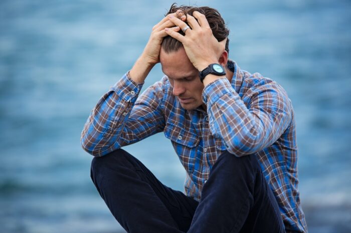 Stress Man In Blue And Brown Plaid Dress Shirt Touching His Hair 897817